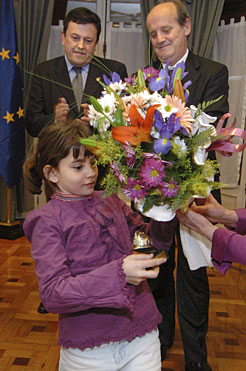 Amaiur Cisneros, hija del bombero José Cisneros, fallecido por enfermedad en diciembre, recibe un ramo de flores en homenaje.