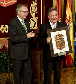 Sanz entrega el escudo de Navarra a Ignacio Lete, representante del centro Salesianos de Pamplona 