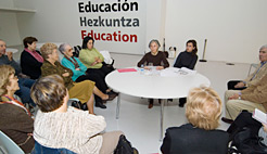 Maite Font (sentada en la mesa a la izquierda del espectador) durante la charla.