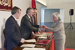Una de las homenajeadas recibe el escudo y el diploma de reconocimiento de manos del Presidente Sanz