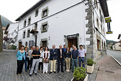 El Presidente Sanz y la consejera Salanueva, junto con los representantes municipales, ante el hostal municipal de Betelu.