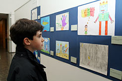 Un niño contempla los dibujos finalistas.
