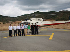 El alcalde de Aoiz y el director de la ANE, junto con el helicóptero en la nueva helisuperficie