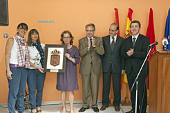 El Presidente Sanz entrega un escudo de Navarra a la directora del centro. 